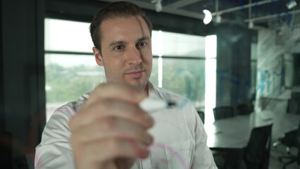 Portrait of professional male leader writing marketing idea on sticky notes. Caucasian businessman...