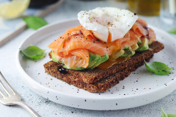 A rye bread sandwich with avocado and salmon	