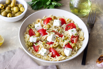 Orzo pasta with white cheese, tomatoes and olives. Healthy eating. Vegetarian food.