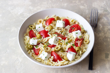 Orzo pasta with white cheese, tomatoes and olives. Healthy eating. Vegetarian food.
