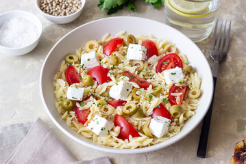 Orzo pasta with white cheese, tomatoes and olives. Healthy eating. Vegetarian food.