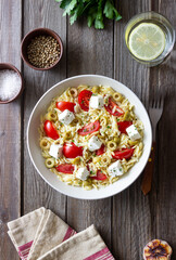 Orzo pasta with white cheese, tomatoes and olives. Healthy eating. Vegetarian food.