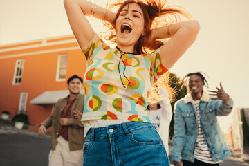 Gen Z friends dancing and recording a fun moment for social media outdoors