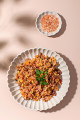 Jambalaya with rice chickpeas and kidney beans on pink table