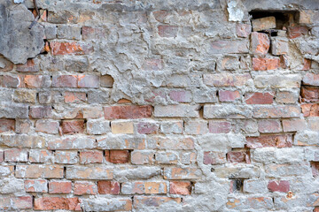 Destroyed plaster on an old red brick wall. Grunge background.