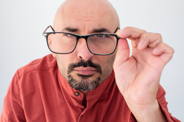 A close-up shot of a man removing his glasses. The expression on his face suggests fatigue or frustration. Perfect for themes of eyewear, vision care, and emotional expression.