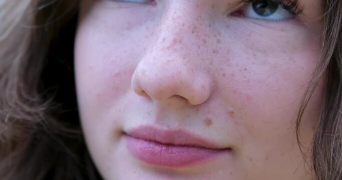 Girl with freckles Close-up face of a teenage girl with freckles licking her lips embarrassed beautiful long thick eyelashes extensions