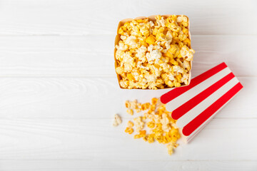 Popcorn box. Red and white striped buckets of popcorn on background. Cinema and entertainment concept. Movie night with popcorn. Cheesy popcorn. Delicious appetizer, snack. Place for text.