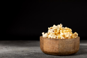Tasty popcorn on woodenbackground. Cinema and entertainment concept. Movie night with popcorn.Cheese and caramel popcorn. Delicious appetizer, snack. Place for text. Copy space.Banner