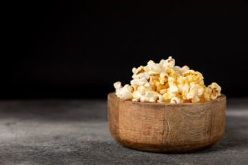 Tasty popcorn on woodenbackground. Cinema and entertainment concept. Movie night with popcorn.Cheese and caramel popcorn. Delicious appetizer, snack. Place for text. Copy space.Banner