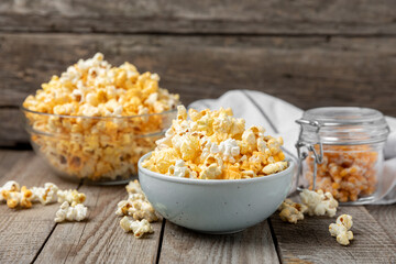 Tasty popcorn on woodenbackground. Cinema and entertainment concept. Movie night with popcorn.Cheese and caramel popcorn. Delicious appetizer, snack. Place for text. Copy space.Banner
