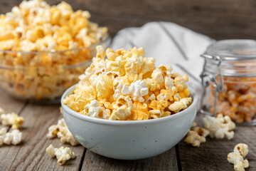 Tasty popcorn on woodenbackground. Cinema and entertainment concept. Movie night with popcorn.Cheese and caramel popcorn. Delicious appetizer, snack. Place for text. Copy space.Banner
