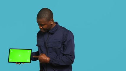 Portrait of smiling security guard at work showcasing isolated screen tablet while overseeing...