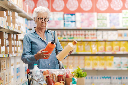 Senior customer comparing products at the supermarket