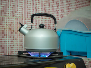 Boil water using a whistling kettle with the stove on