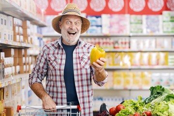 Surprised happy farmer buying fresh vegetables at the supermarket