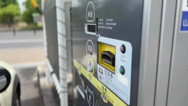 駐車券を入れる女性の手元