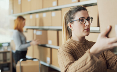 Obraz premium Woman moving delivery boxes in the warehouse
