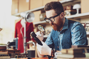 Young business owner checking vintage items in his shop