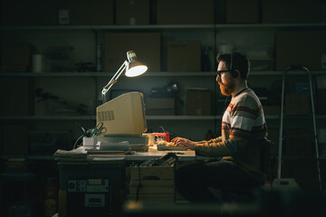 Smart nerd man working with an old PC at night