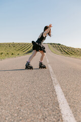Woman in dress dance on roller skates outdoor on sunny day