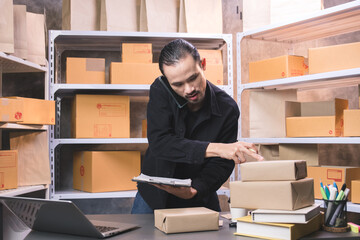 Small business entrepreneur using smartphones and laptops to check orders received from customers to prepare for shipping, online marketing, packaging boxes, SME sellers , online sales.