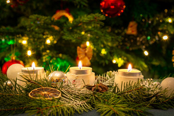 Candles in front of the Christmas tree.