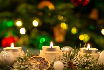 Candles in front of the Christmas tree.