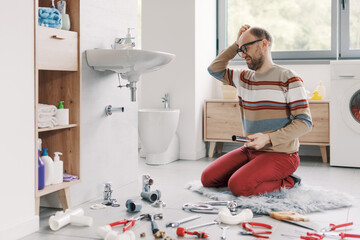 Confused man repairing his bathroom sink
