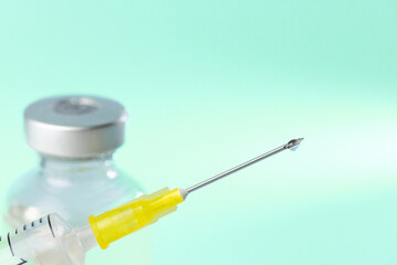 medical syringe and a bottle of injectable medication in a pharmaceutical laboratory blue background copy space © VICTOR