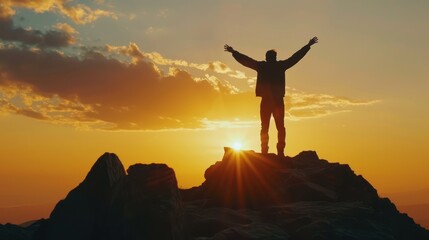 A powerful silhouette of a businessman triumphantly raising his arms on top of a mountain at sunset, representing the fulfillment of his aspirations and dreams. 