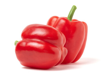 Isolated Two Red Bell Pepper on White. Two vibrant, glossy red bell peppers, one standing upright and another resting beside it, perfectly isolated on a pure white background, ideal for culinary.