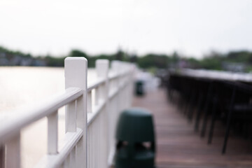 White wooden balcony railing of a riverside restaurant light blur background