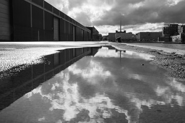 Obraz premium Reflective Puddle in Urban Setting