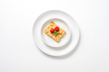 Top view of a cheesy casserole on a white plate