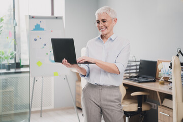 Photo of attractive good mood age lady agent dressed formal shirt chatting modern device indoors...