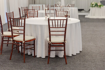 Decorated interior for festive event. Fancy table set for dinner in restaurant, luxury interior background. Wedding elegant banquet decoration arranged by catering service