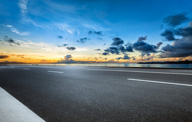 Empty asphalt road and cloudscape by the sea