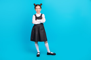Full body photo of cute little girl crossed hands confident dressed stylish school uniform isolated on blue color background