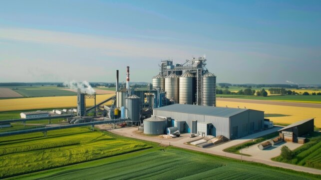 Aerial shot of industrial complex with tall silos and smokestacks, surrounded by farmland, showcasing the contrast between industry and agriculture.