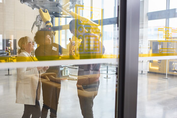 Group of engineers discussing robotics and automation in a modern industrial facility