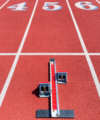 Looking at runners starting blocks in lane five on a red track