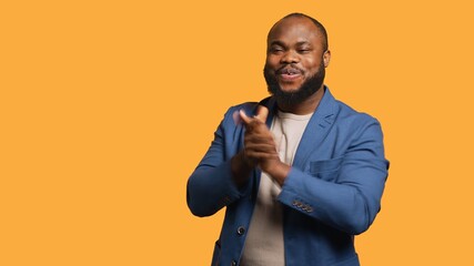 Approving joyful african american man happily clapping hands, ecstatic about accomplishments. Excited BIPOC person cheering, applauding, isolated over studio background, camera A