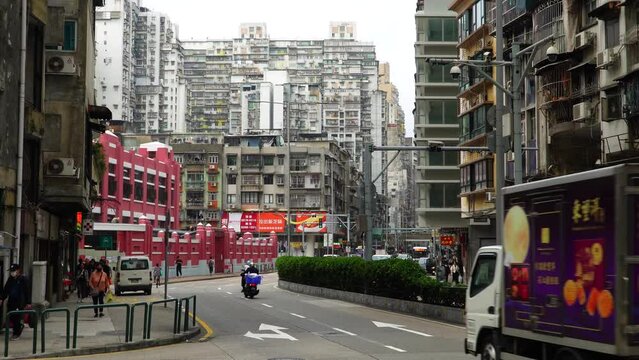 Macau - March 25, 2024: View of a busy street with people and passing cars in the city center of Macau, China.