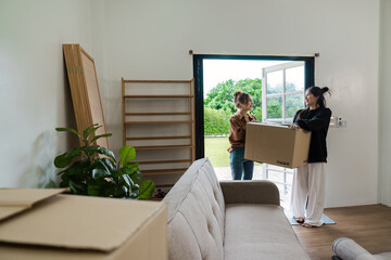 LGBT lesbian Couple Moving into New Home with Cardboard Boxes and Furniture in Modern Living Room