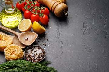 Cooking scene: Cherry tomatoes, pasta, spices on table