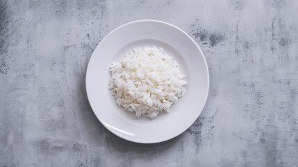 Rice served on a white plate against a gray concrete backdrop
