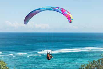 Paraglider flies in front of the ocean