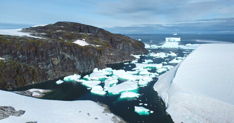 Group of icebergs melting glacier floating in Antarctic mountain rock canyon bay frozen river. Polar winter ocean landscape in sunny day. Antarctica travel exploration. Aerial view rise up panorama.