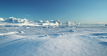Winer snow covered Antarctica aerial landscape. Frozen ocean and towering mountain range under blue clear sky, sunny wild nature scene. Sea polar coast hill. Antarctic travel exploration background © mozgova